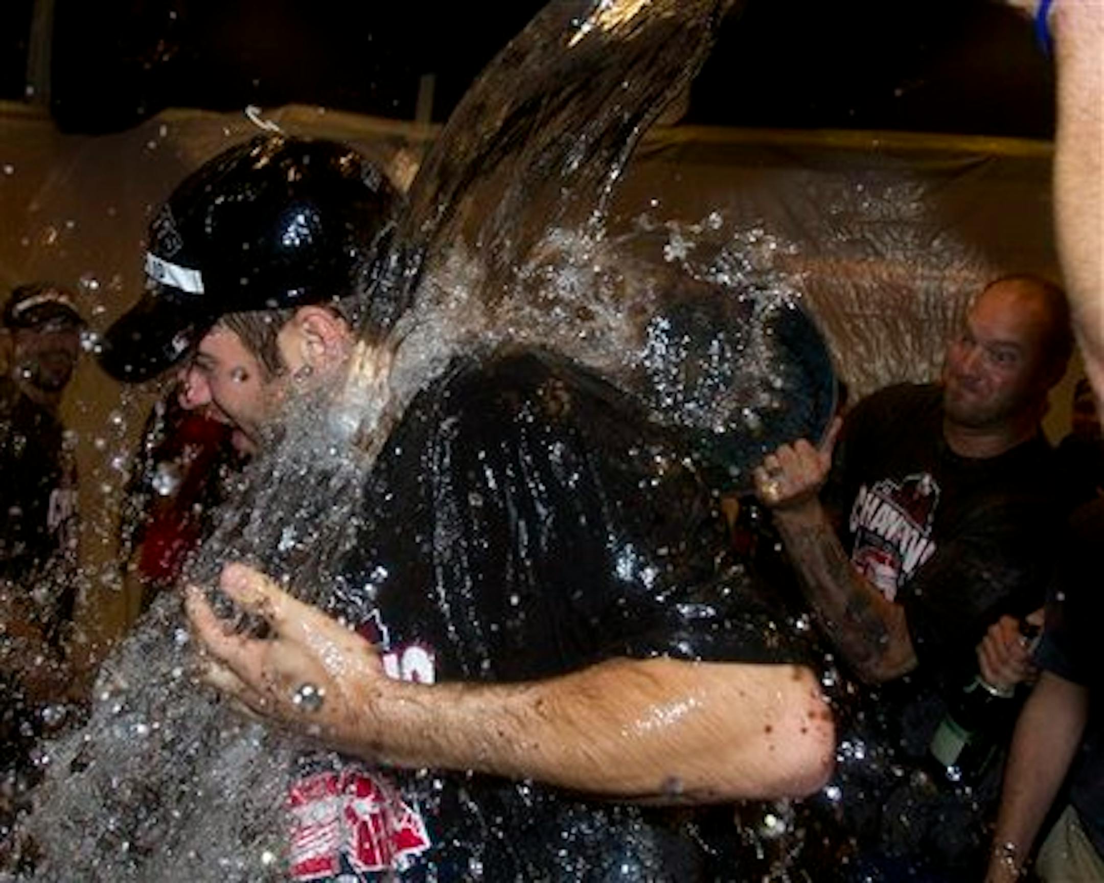 Minnesota Twins' Joe Mauer is doused by teammates as they celebrate after clinching the American League Central division Wednesday, Sept. 22, 2010, in Minneapolis. The Twins beat the Indians 6-4 and the White Sox lost to the Athletics 7-2 to clinch the title. (AP Photo/Jim Mone)