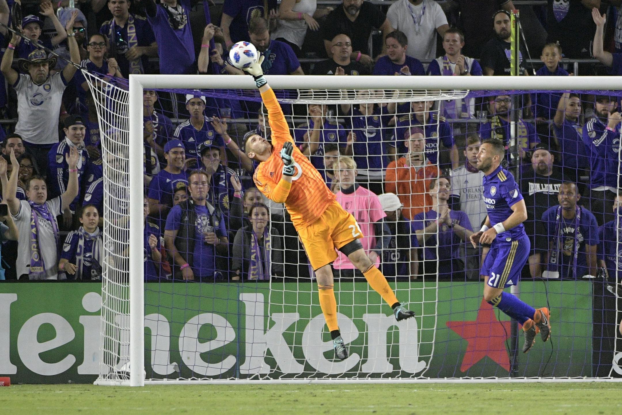 Minnesota United goalkeeper Matt Lampson (28) blocks a shot in front of Orlando City midfielder Scott Sutter (21) during the second half of an MLS soccer game Saturday, March 10, 2018, in Orlando, Fla. Minnesota won 2-1.