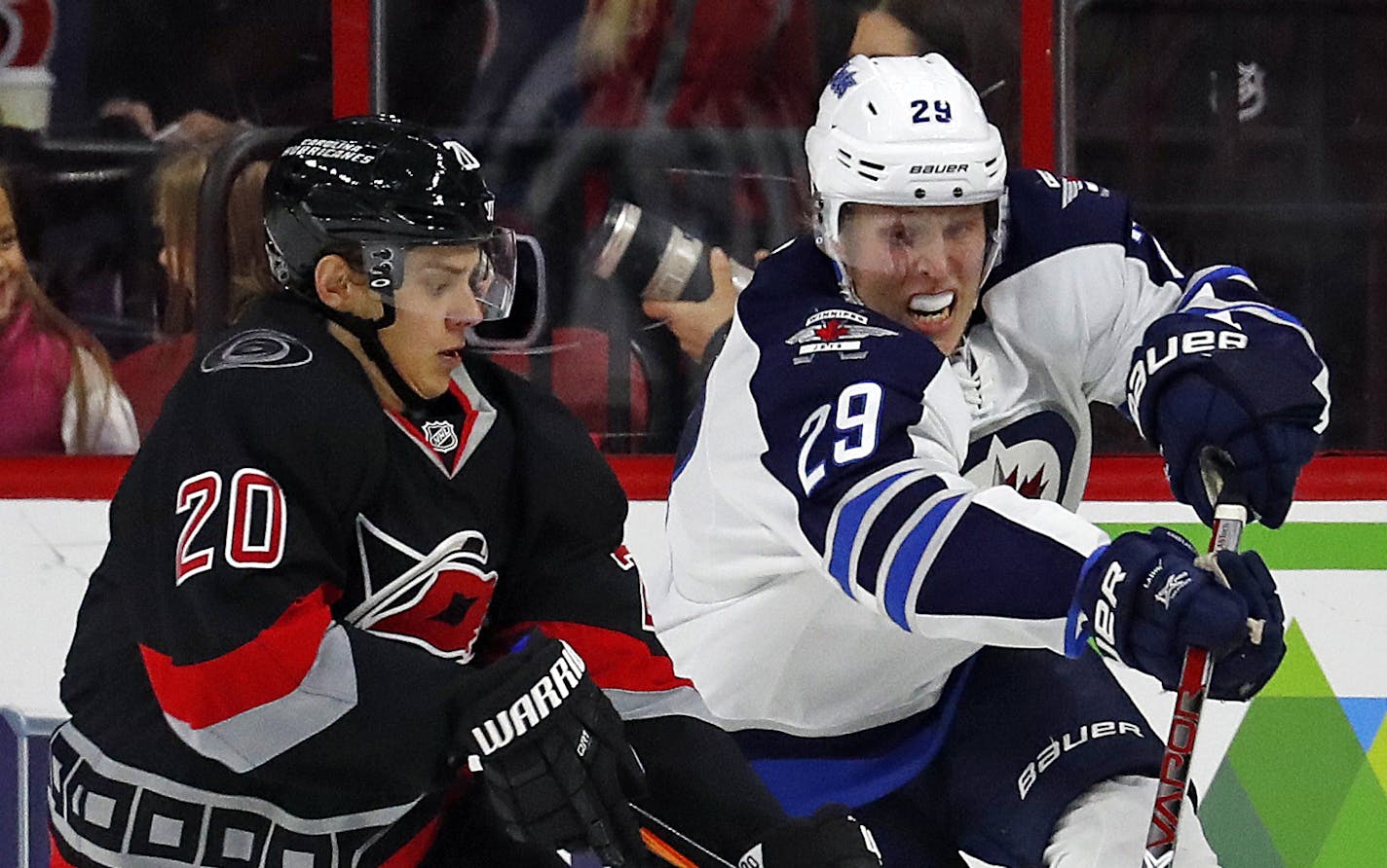 Winnipeg Jets' Patrik Laine (29) battles Carolina Hurricanes' Sebastian Aho (20) during the second period of an NHL hockey game, Sunday, Nov. 20, 2016, in Raleigh, N.C. (AP Photo/Karl B DeBlaker)