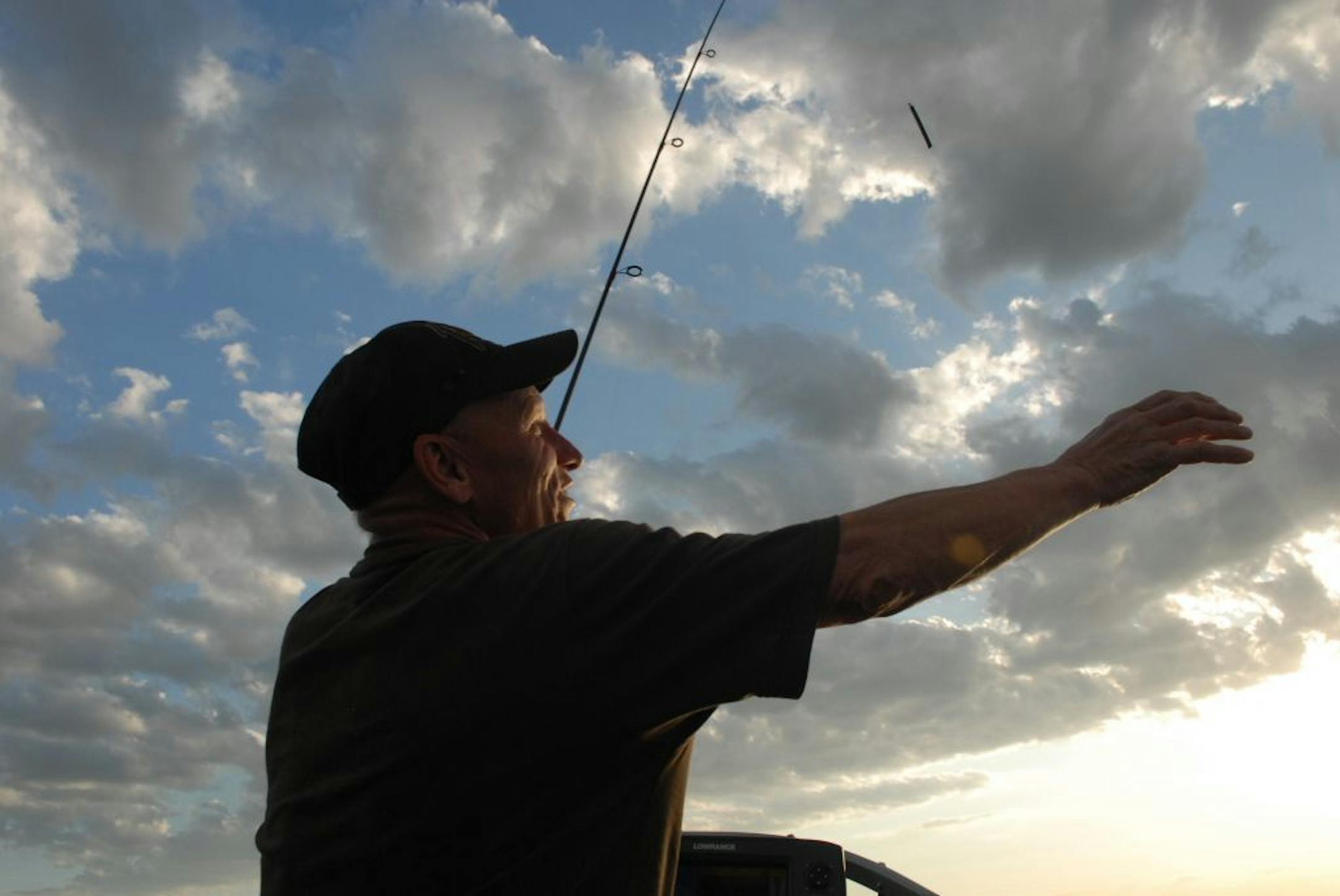 Larry Blaske reaches for his bottom bouncer lead weight and spinner rig while fishing for walleyes on Mille Lacs last year.