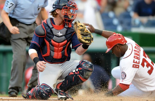 Washington Nationals left fielder Roger Bernadina (33) scores ahead of a tag by Minnesota Twins catcher Chris Herrmann (12) in the first inning of the