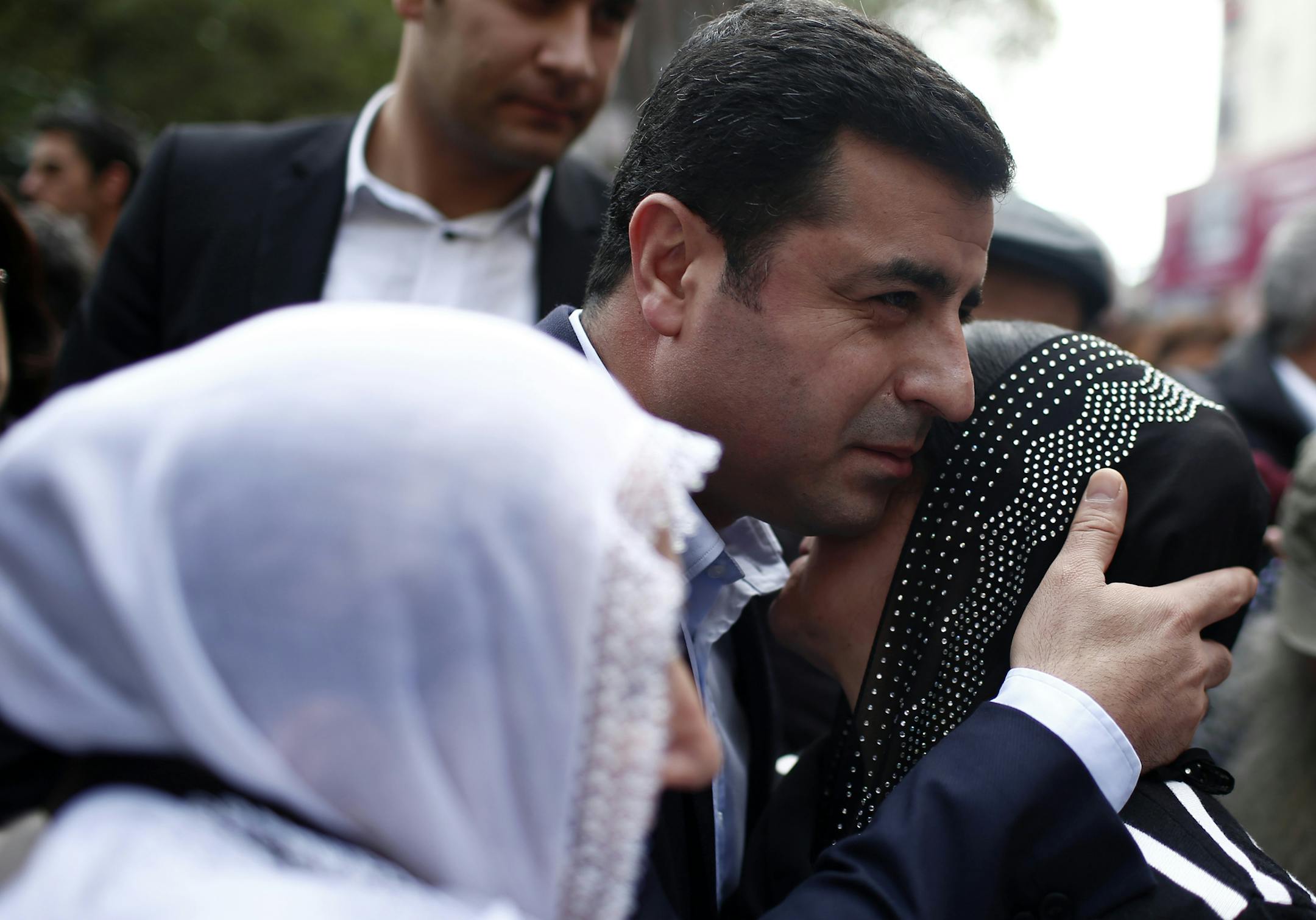 Selahattin Demirtas, co-chair of the pro-Kurdish Peoples' Democratic Party, (HDP), center , hugs a woman as he attends a sit-in of Saturday Mothers during their 553rd gathering, at Galatasaray Square, in Istanbul Turkey, Saturday, Oct. 31, 2015. Protesters , who call themselves Saturday Mothers, meet at Galatasaray square in central Istanbul every Saturday, demanding to know the fate of missing people and the prosecution of those responsible and demanding to know the fate of their missing relati