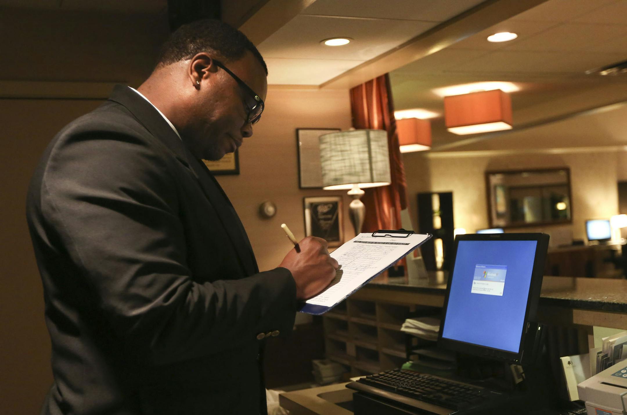 Local pro boxer, Aaron " Gorilla" Greene signed out the keys before his sweep of the building at the Double Tree hotel in Minneapolis Min., Thursday, August 1, 2013. Greene works as a security guard on the over night shift. ] (KYNDELL HARKNESS/STAR TRIBUNE) kyndell.harkness@startribune.com