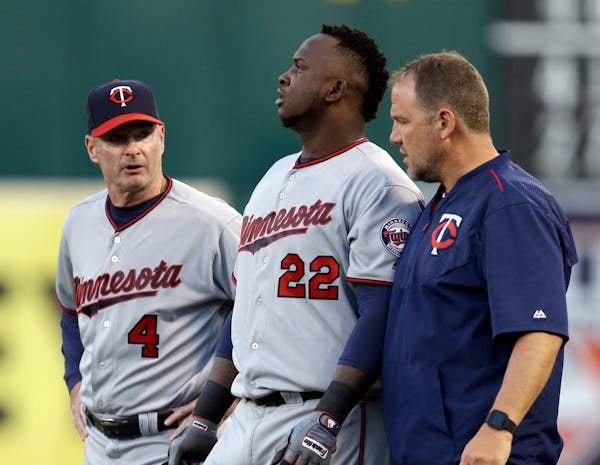 Minnesota Twins manager Paul Molitor, left, and a trainer walk Miguel Sano (22) off the field after an injury sustained in the third inning of a baseb