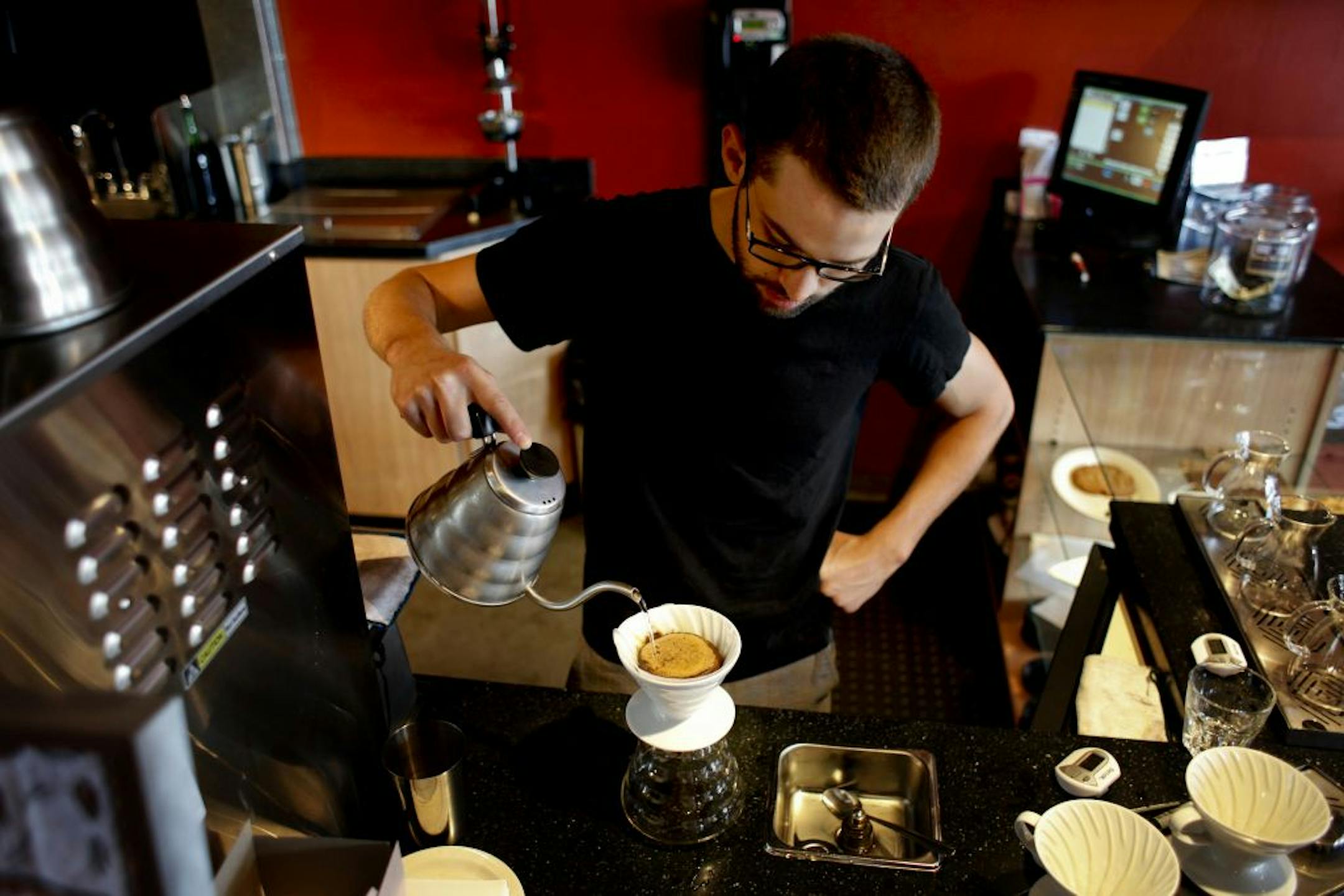 At the Quixotic coffee shop employee Nathan Barten makes a pourover hand-crafted cup of coffee in St. Paul, Minn. on Tuesday, July 13, 2012.