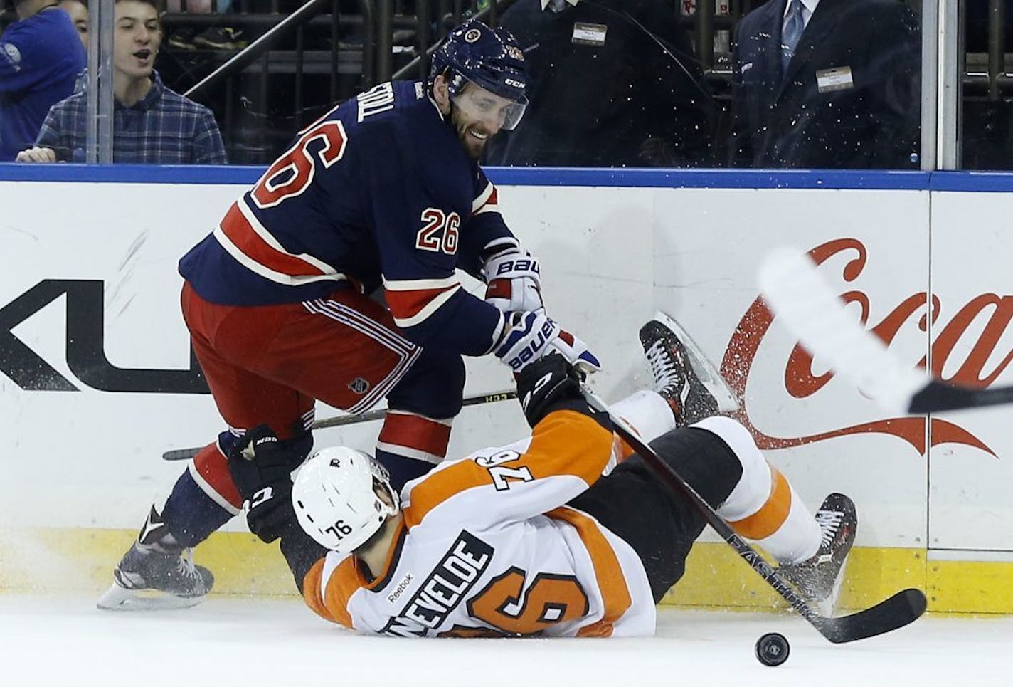 Philadelphia Flyers center Chris VandeVelde (76) loses his footing as he fights for control of the puck against New York Rangers center Jarret Stoll (26) during the second period of an NHL hockey game, Saturday, Nov. 28, 2015, in New York.