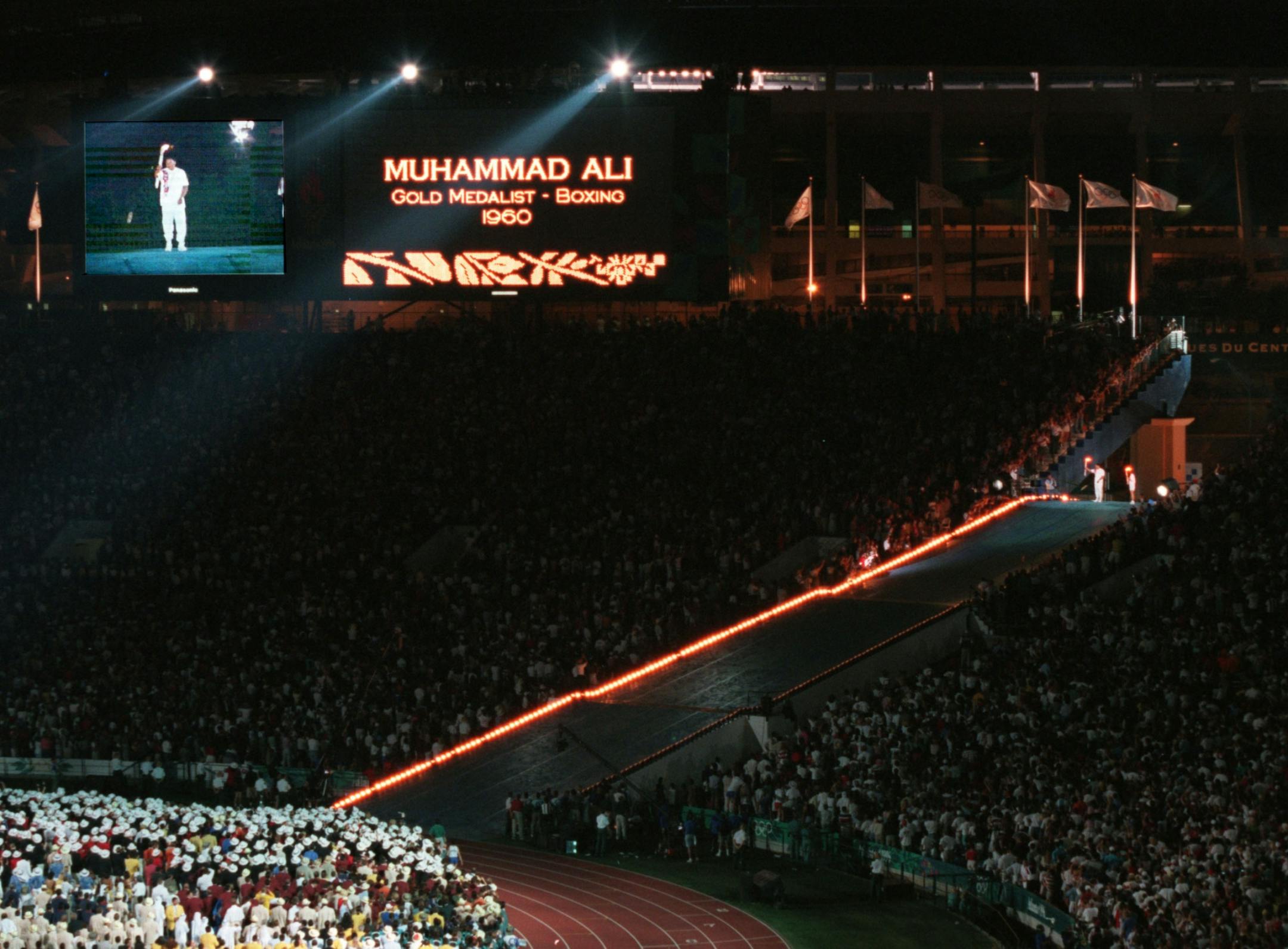 Opening ceremonies for the 1996 Olympic Games in Atlanta. -- 1960 boxing gold medalist Muhammad Ali stands with fellow gold medalist Janet Evans, after she lit his torch. Ali then lit the flame that burned up a cable and lit the Olympic Torch at the climax of the opening ceremonies Friday night.