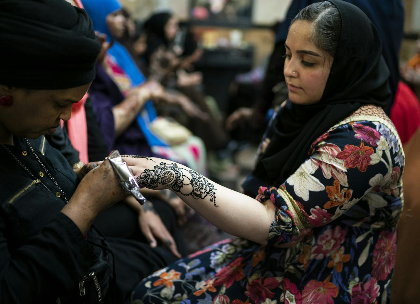 Warda Hashi drew a henna design on Tabasum Sadozai in preparation for Eid at Sihaam Henna at Karmel Mall in Minneapolis, Minn., on Monday, June 3, 2019. Sadozai comes up to Karmel every year from Prior Lake to get henna for Eid. RENEE JONES SCHNEIDER • renee.jones@startribune.com