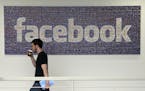 FILE - In this March 15, 2013, file photo, a man walks past a sign at Facebook headquarters in Menlo Park, California, USA. Facebook gave some compani