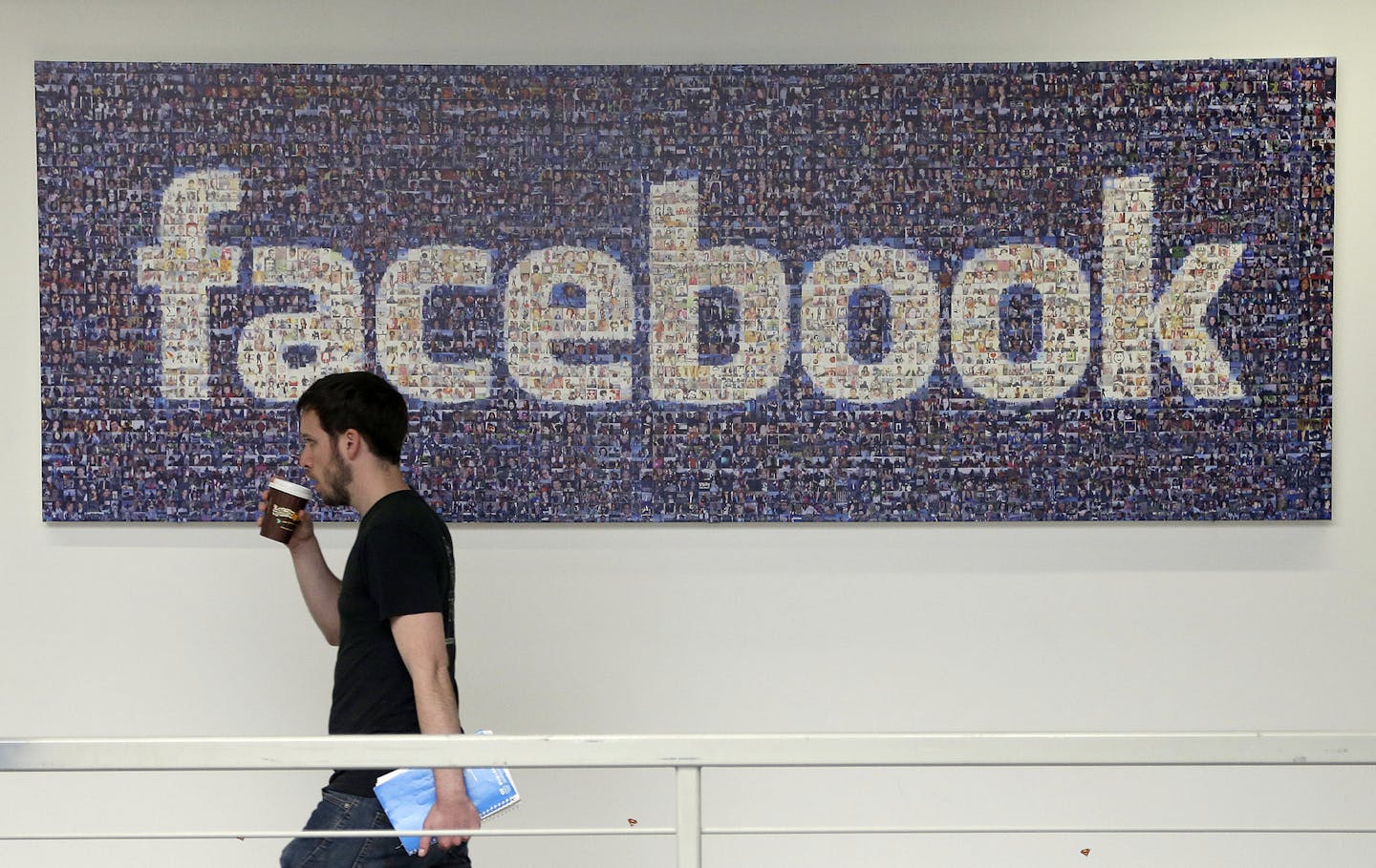 FILE - In this March 15, 2013, file photo, a man walks past a sign at Facebook headquarters in Menlo Park, California, USA. Facebook gave some companies more extensive access to users&#x2019; personal data than it has previously revealed, letting them read private messages or see the names of friends without consent, according to a New York Times report published Wednesday Dec. 19, 2018. (AP Photo/Jeff Chiu, File)