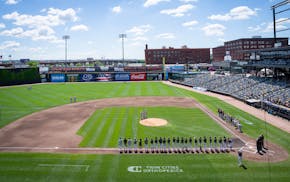 High school baseball teams stand for the national anthem before playing a state tournament game at CHS Field in 2024.