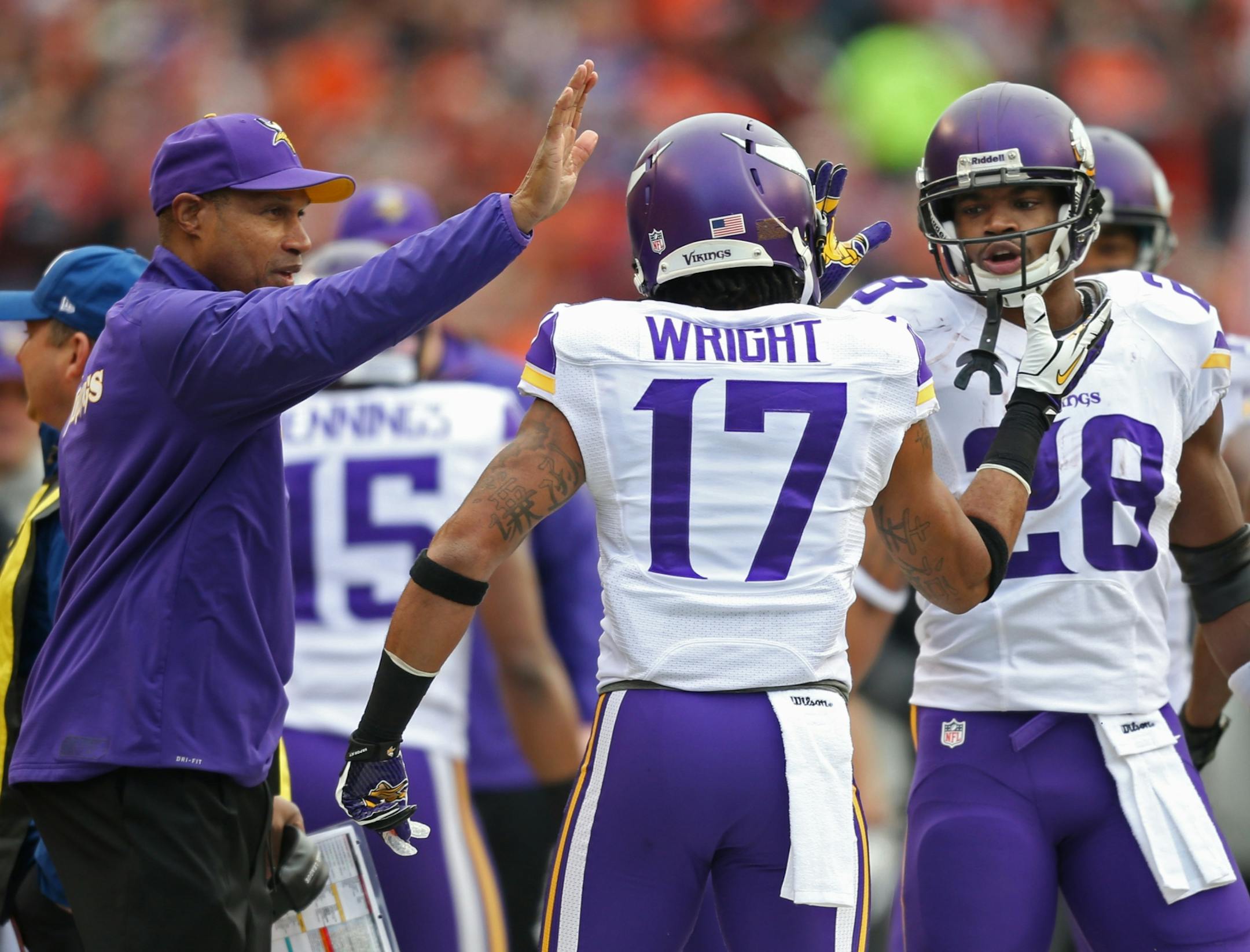 Minnesota Vikings wide receiver Jarius Wright (17) celebrated with running back Adrian Peterson (28) and head coach Leslie Frazier after catching a 36-yard touchdown pass from Matt Cassel.