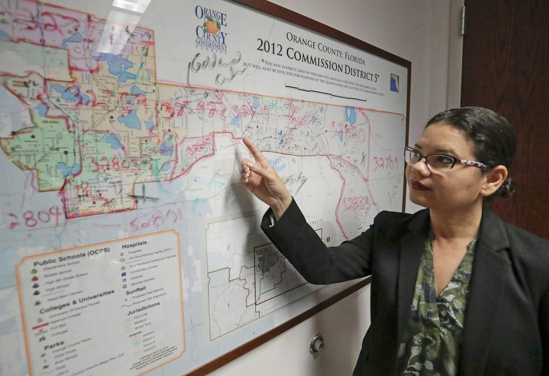 In this Monday, June 3, 2019, photo, Orange County Commissioner Emily Bonilla looks at a map of Orange County and the city of Orlando in Orlando, Fla. Bonilla is worried her district in metro Orlando will be undercounted during next spring's once-in-a-decade head count of everybody in the United States because of who lives there: new arrivals, immigrants, the poor, renters and people living in rural areas who sometimes regard government with suspicion.