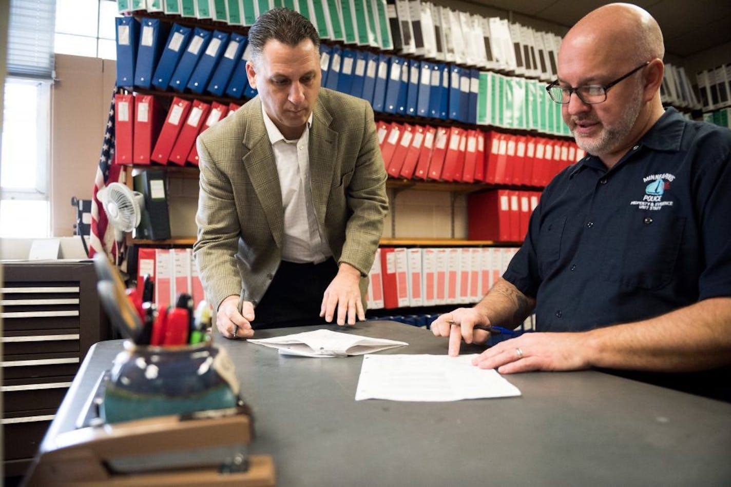 Homicide Sgt. Chris Karakostas and evidence technician Jeffery Hayes sign for the evidence they retrieved.