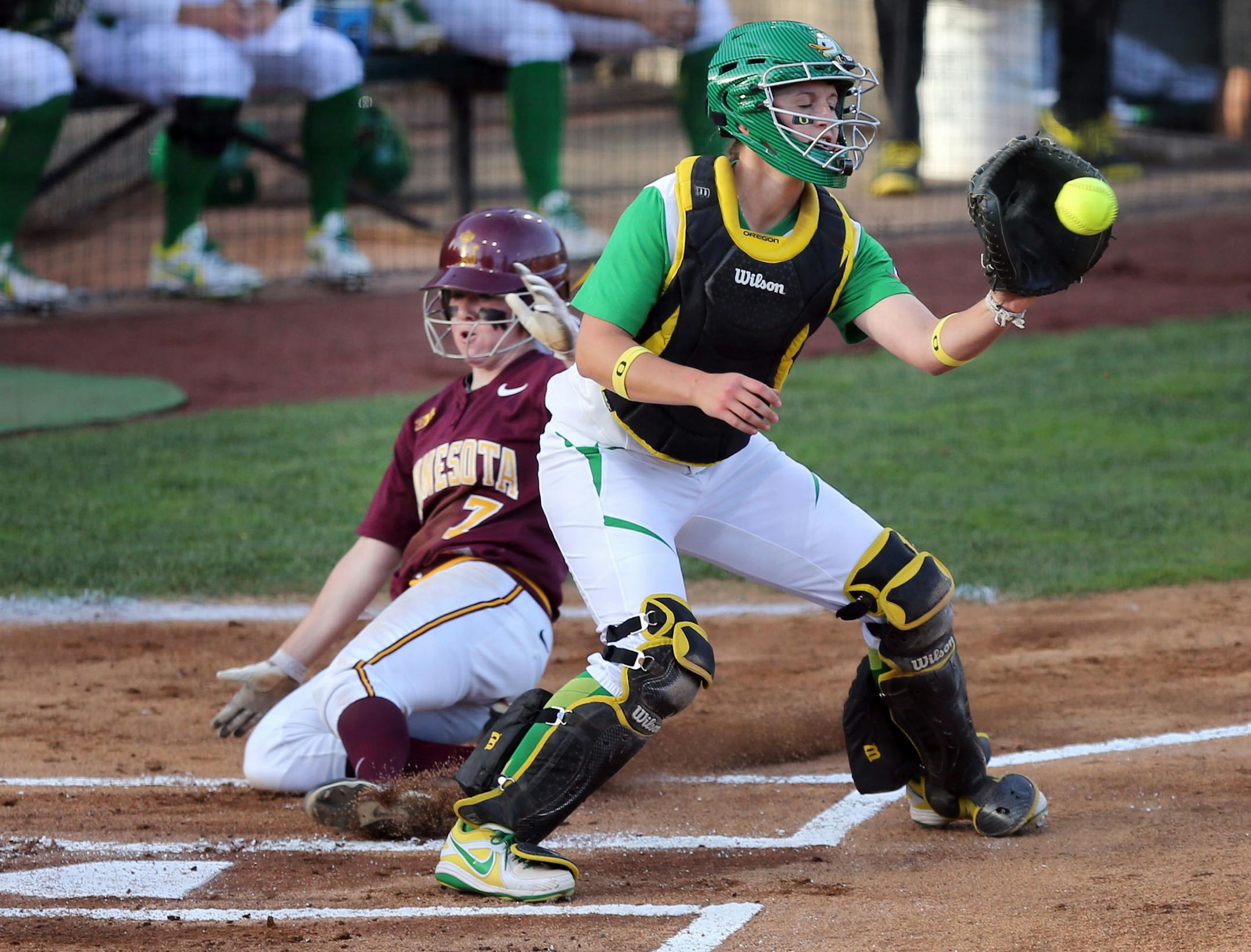 Minnesota's Sam Macken (left) slides home ahead of the throw to Oregon catcher Alexa Peterson for the first score of the game during first inning in the NCAA Softball Eugene Super Regional 2014 Saturday May 24, 2014. (Chris Pietsch/For The Star Tribune)