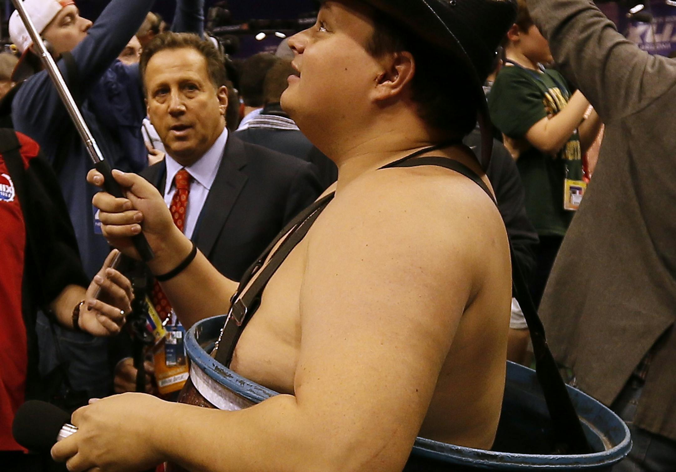 A radio station reporter, wearing a barrel, takes selfies during media day for NFL Super Bowl XLIX football game Tuesday, Jan. 27, 2015, in Phoenix. (AP Photo/Matt York) ORG XMIT: NFL147