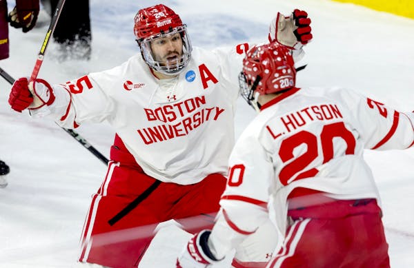 Boston University's Sam Stevens, left, and Lane Hutson celebrate Hutson's go-ahead second-period goal against the Gophers on Saturday in Sioux Falls, 