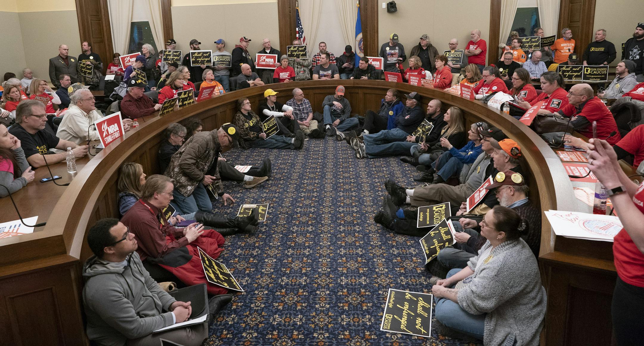 The overflow room was full as supporters on both sides listened as the House public safety committee talked about two bills that would expand background checks and adopt a "red flag" law at the State Capitol Wednesday, Feb. 27, 2019, in St. Paul, Minn. The Minnesota House committee has voted to require universal criminal background checks for gun purchasers. (Jerry Holt/Star Tribune via AP)