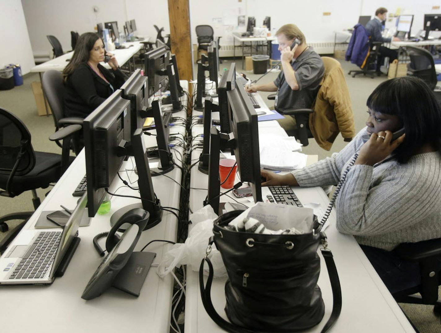 Guides work the phones Tuesday, Dec. 31, 2013, in St. Paul, Minn. for shoppers scrambling to finalize health coverage before the new year at Minnesota's insurance marketplace. The call center was the fallback for health insurance shoppers vexed by the troubled MNsure website. People who wanted to guarantee they'll be covered from Wednesday forward had to complete enrollment by Tuesday. (AP Photo/Jim Mone) ORG XMIT: MIN2014011016563052