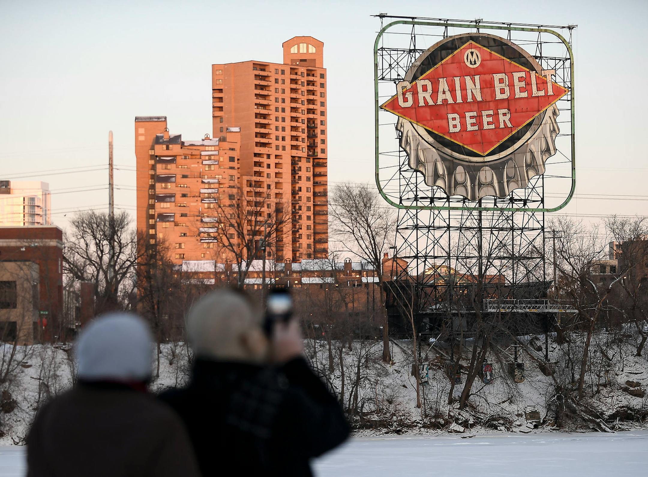 From left, Robbin and John Leach, from Lino Lakes, took photos of the Grain Belt sign before its relighting ceremony Saturday night.
