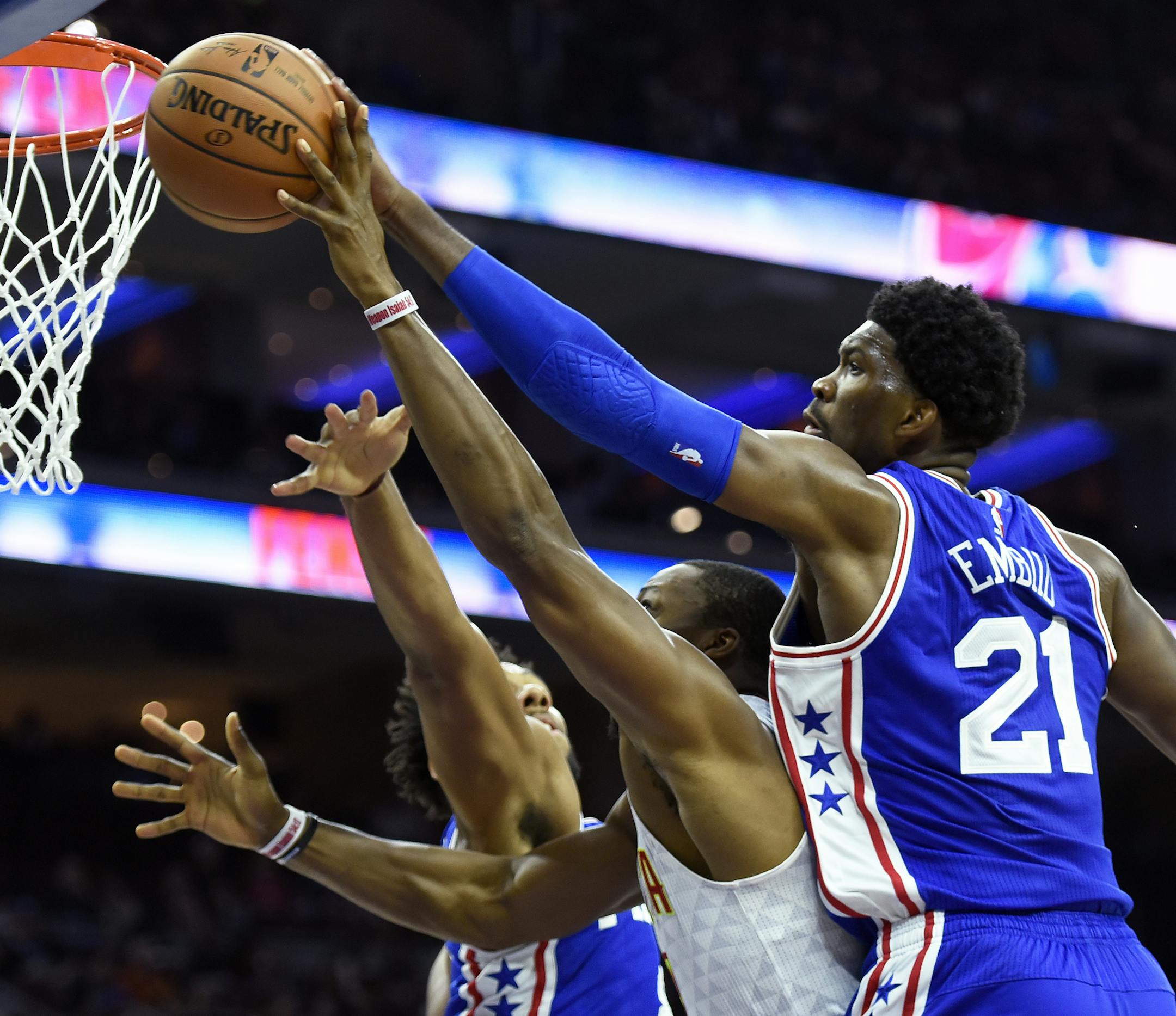 Philadelphia 76ers' Joel Embiid (21) blocks a shot taken by Atlanta Hawks' Dwight Howard, center, during the first half of an NBA basketball game, Saturday, Oct. 29, 2016, in Philadelphia. (AP Photo/Michael Perez)