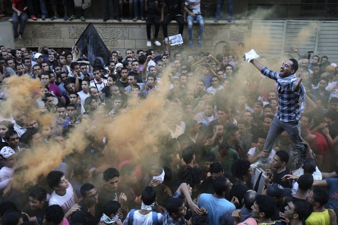 Protesters chant slogans amid orange smoke outside the U.S. embassy in Cairo, Egypt, Tuesday.