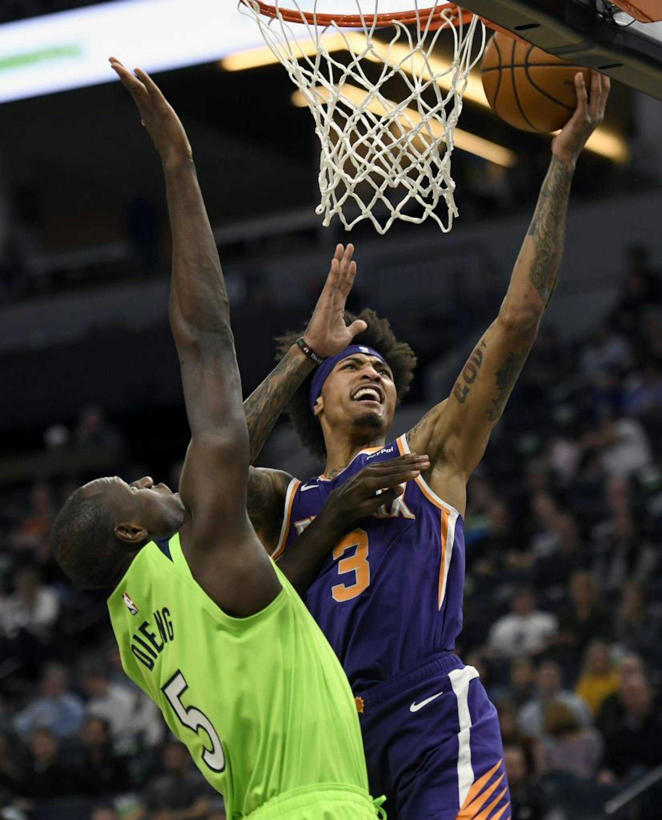 Minnesota Timberwolves center Gorgui Dieng (5) fouls Phoenix Suns forward Kelly Oubre Jr. (3) while shooting during the first quarter of an NBA basketball game on Saturday, Nov. 23, 2019, in Minneapolis.