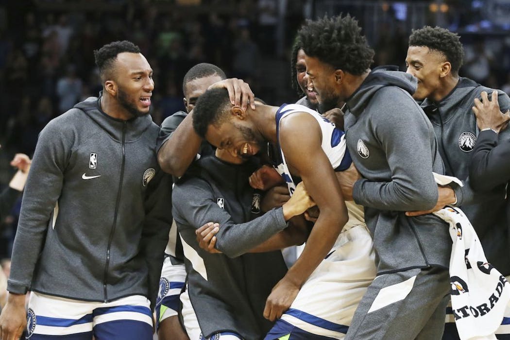 Andrew Wiggins (22) is swarmed by teammates after his third straight 3-pointer against the Miami Heat in the second half on Sunday night.