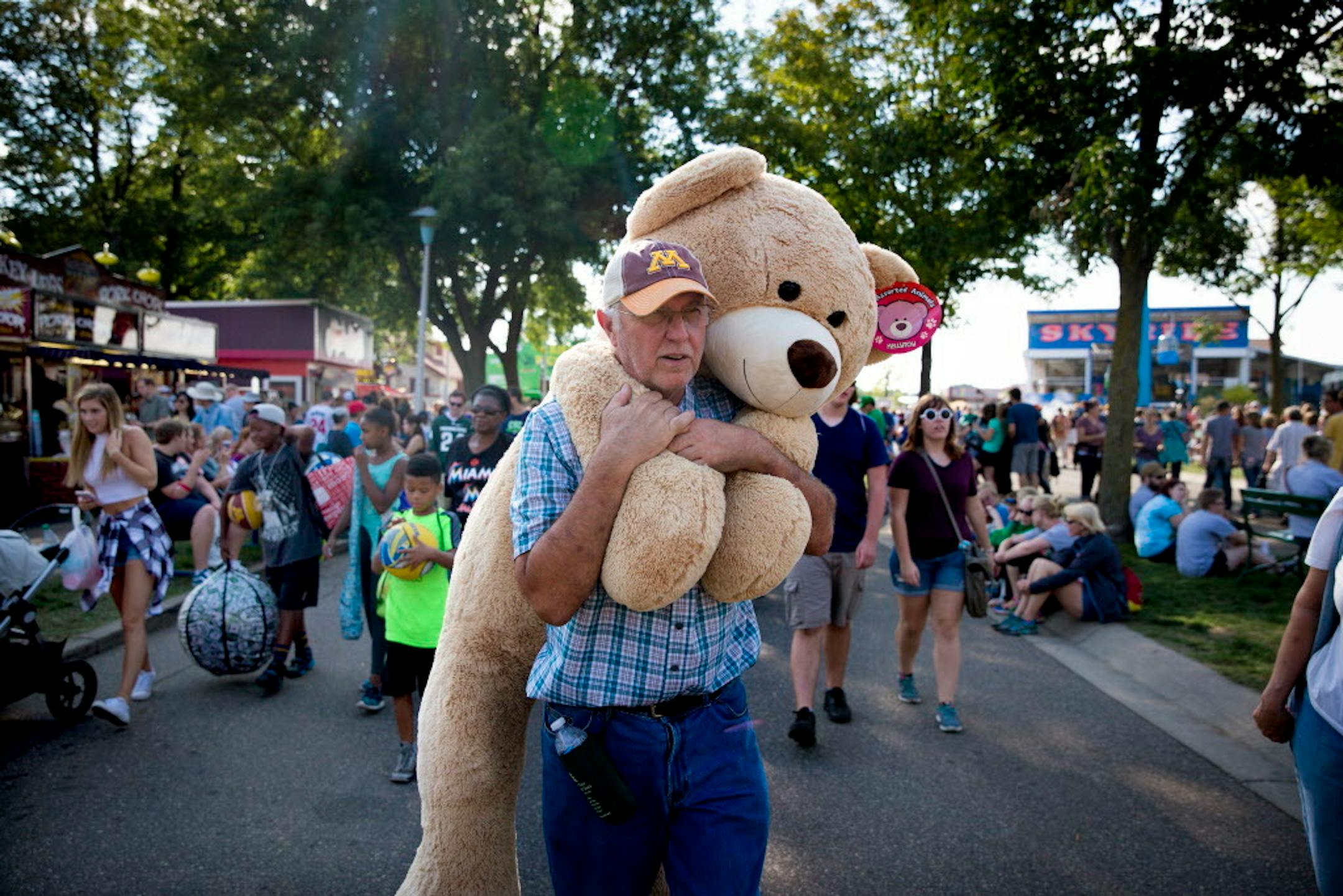 Neil Pence of Northfield carried his prize from a "machine gun BB gun" game at the Midway on day one of the Minnesota State Fair in Falcon Heights, Minn., on August 25, 2016. According to Pence, he wins big stuffed animals and toys every year since he was a teenager and has a habit of donating them to random kids. ] RENEE JONES SCHNEIDER � renee.jones@startribune.com