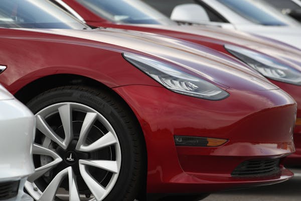 In this Wednesday, May 6, 2020, photograph, unsold 2020 Model 3 sedans sit at a Tesla dealership in Superior, Colo. (AP Photo/David Zalubowski)
