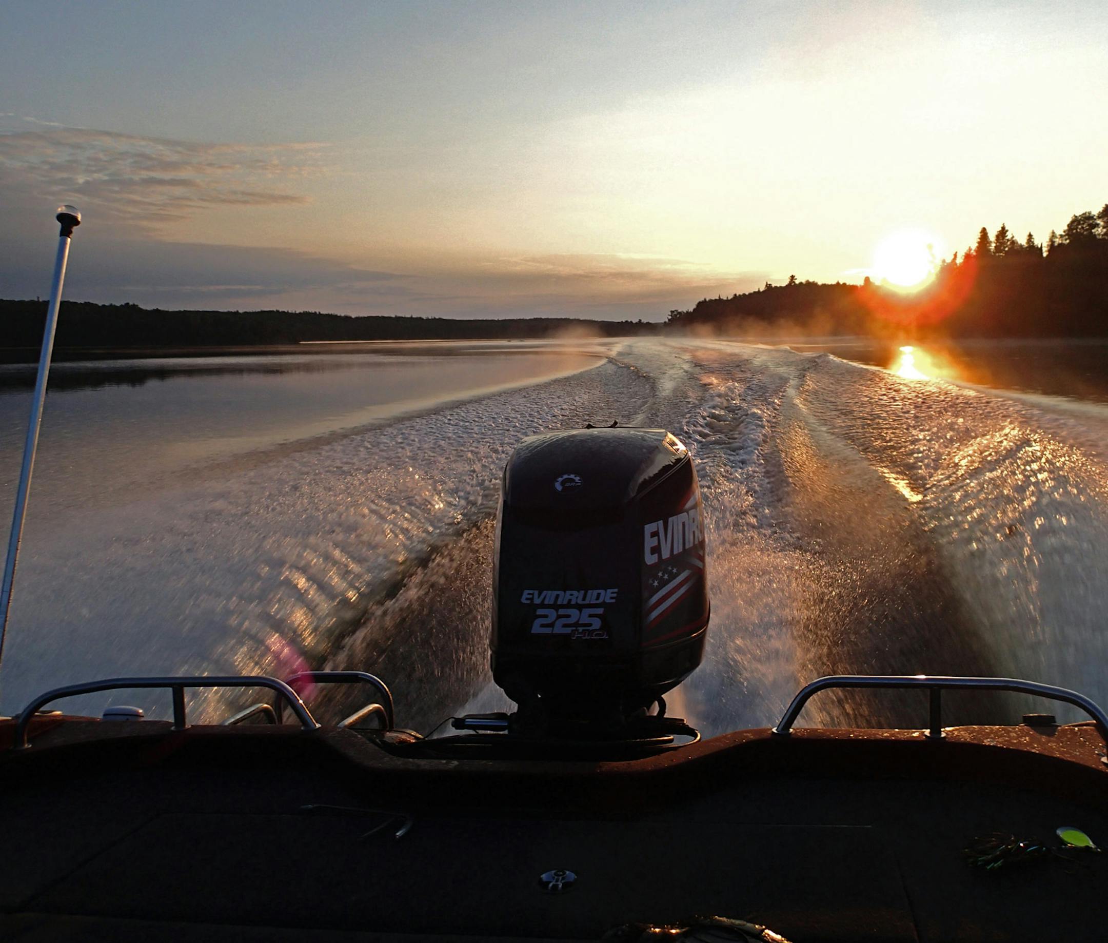 As the sun rose over the treetops lining Lake of the Woods, a boat carrying anglers to favorite fishing spots carved a picturesque wake.