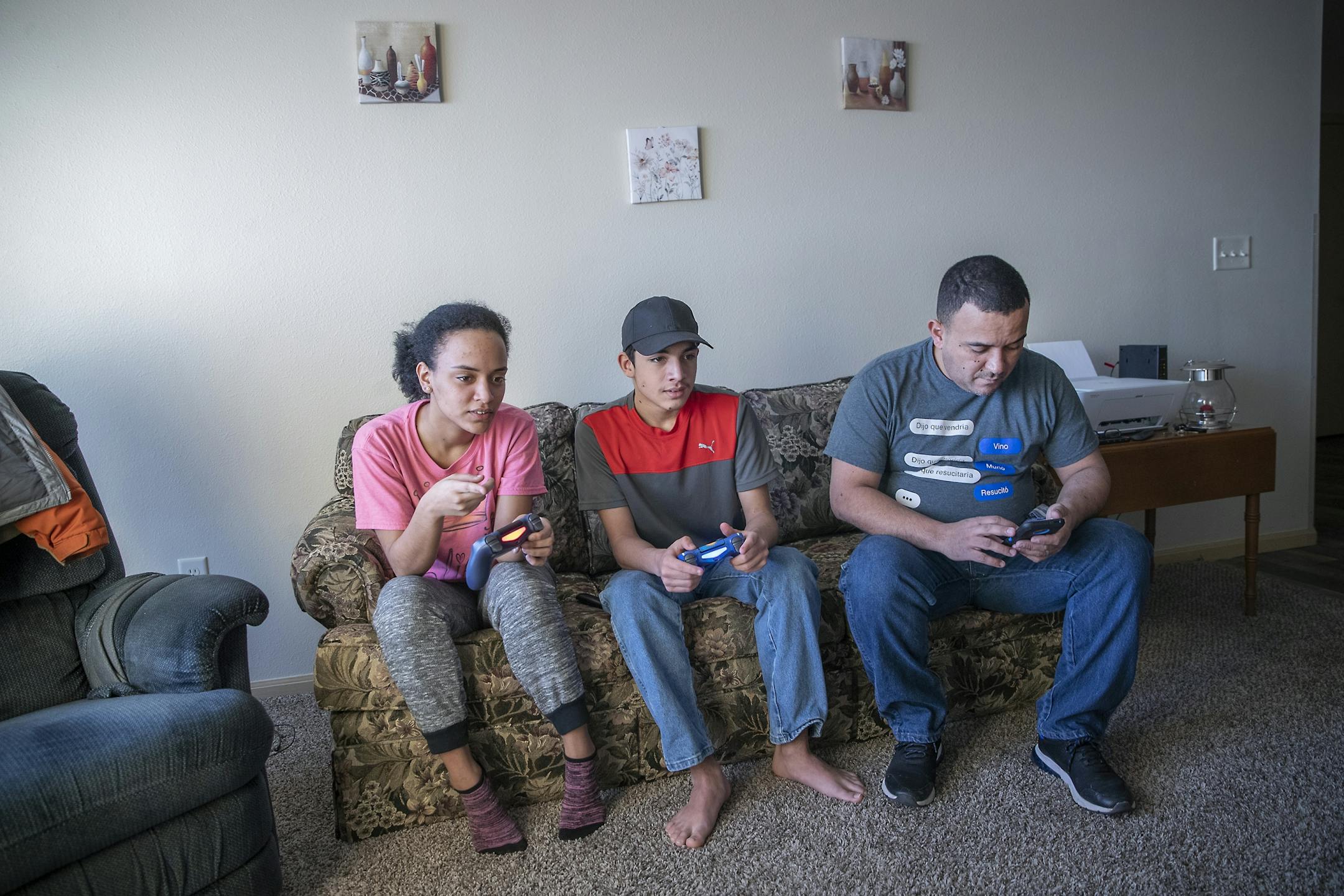 Elias Bastardo, far right, waited for his ride to begin his shift at the Polaris plant as his kids, Elienith, 17, left, and Elias Jr., center, played video game at their home, Monday, February 17, 2020 in Roseau, MN.