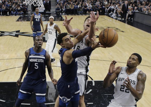 Minnesota Timberwolves guard Tyus Jones (1) tires to score past San Antonio Spurs center Pau Gasol (16) and forward Rudy Gay, right, during the first 