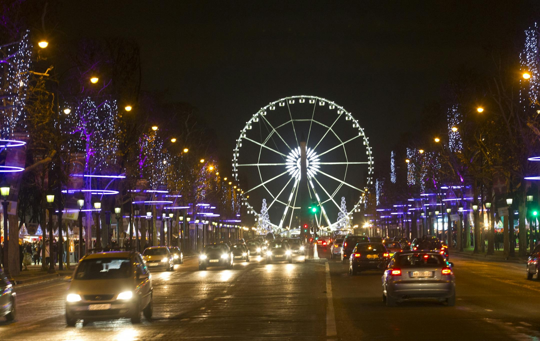 The traffic moves along the Champs Elysees looking towards the Place de la Concorde, Thursday, Dec 6, 2012 in Paris. Trees are lit - along with a big wheel - in the Tuileries gardens for Christmas.