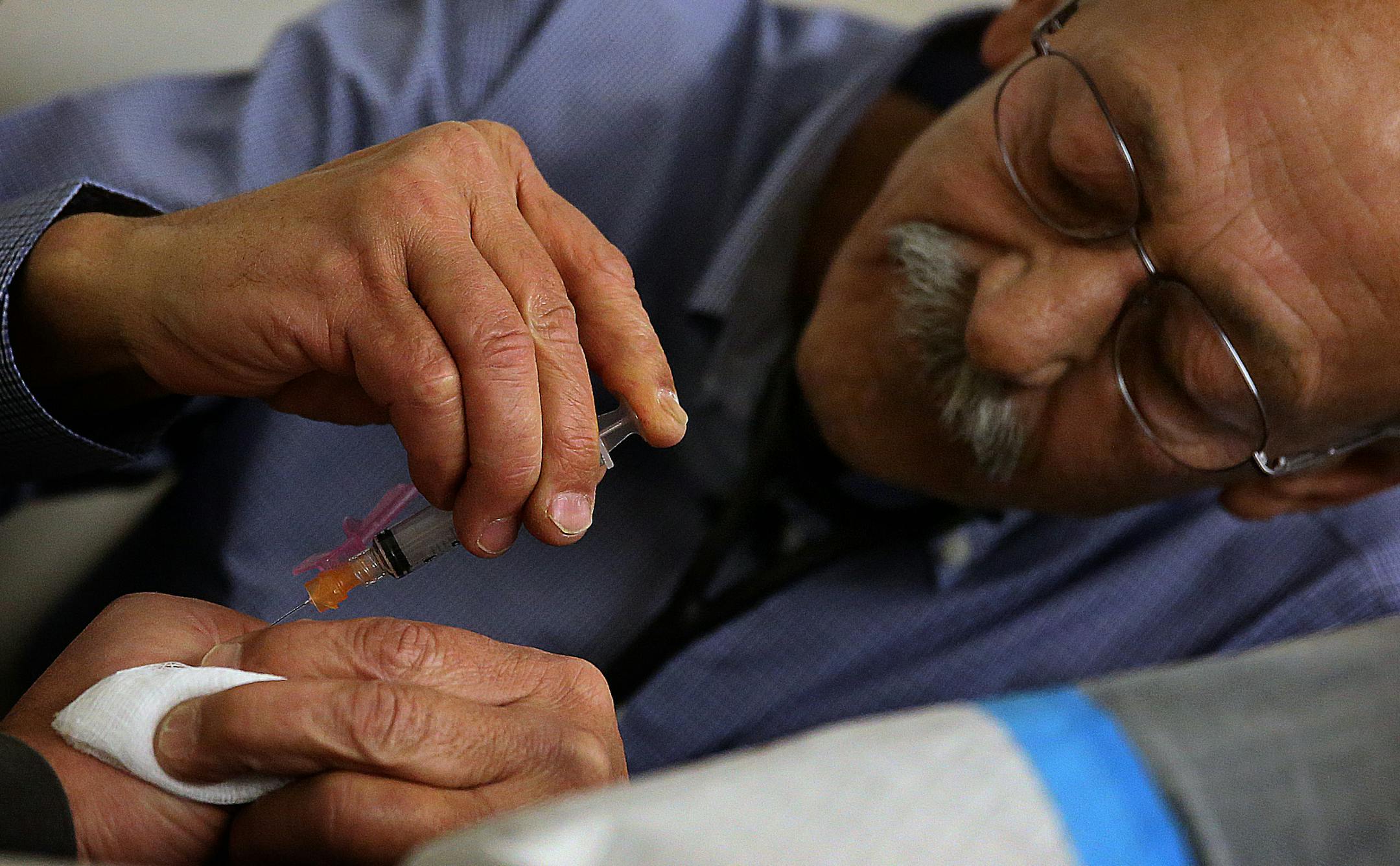 Dr. Robert B&#xf6;sl, recently named Country Doctor of the Year, prepared to stitch up a wound on the hand of Jordan Johnsrud, 25.