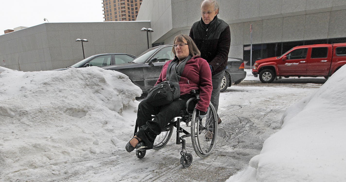 Margot Imdieke Cross got help from her husband Stuart Cross to get up onto a sidewalk covered in ice at her work, Friday, February 28, 2014 in St. Paul, MN. ] (ELIZABETH FLORES/STAR TRIBUNE) ELIZABETH FLORES &#x2022; eflores@startribune.com