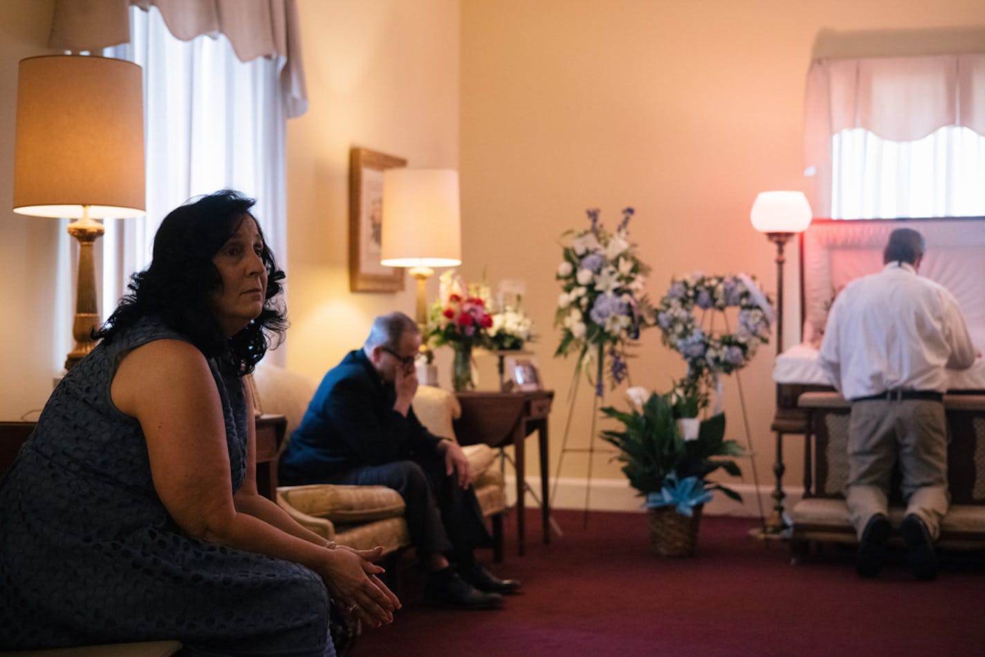 Michele Preissler at the viewing for her husband Darryl, who died of COVID-19, at a funeral home in Pasadena, Md., May 26, 2021. COVID-19 hospitalizations and deaths in the U.S. are lower than they have been in many months and vaccination rates continue to slowly climb. But there are still about 450 deaths reported each day, and that has left hundreds of families dealing with a new kind of pandemic grief. (Alyssa Schukar/The New York Times)