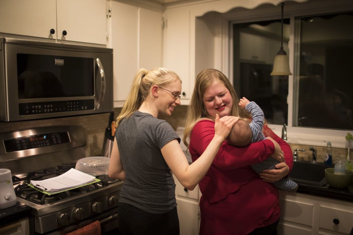 Melissa Ellis, right, held baby Kai Sanborn as Kai's mother Kelly Sanborn greeted him after she woke up to pump during Ellis' overnight doula shift on Wednesday, October 25, 2017, in Maple Grove, Minn. Ellis has been coming for overnights to help Sanborn who has struggled with postpartum depression and because Kai is a very fussy baby.