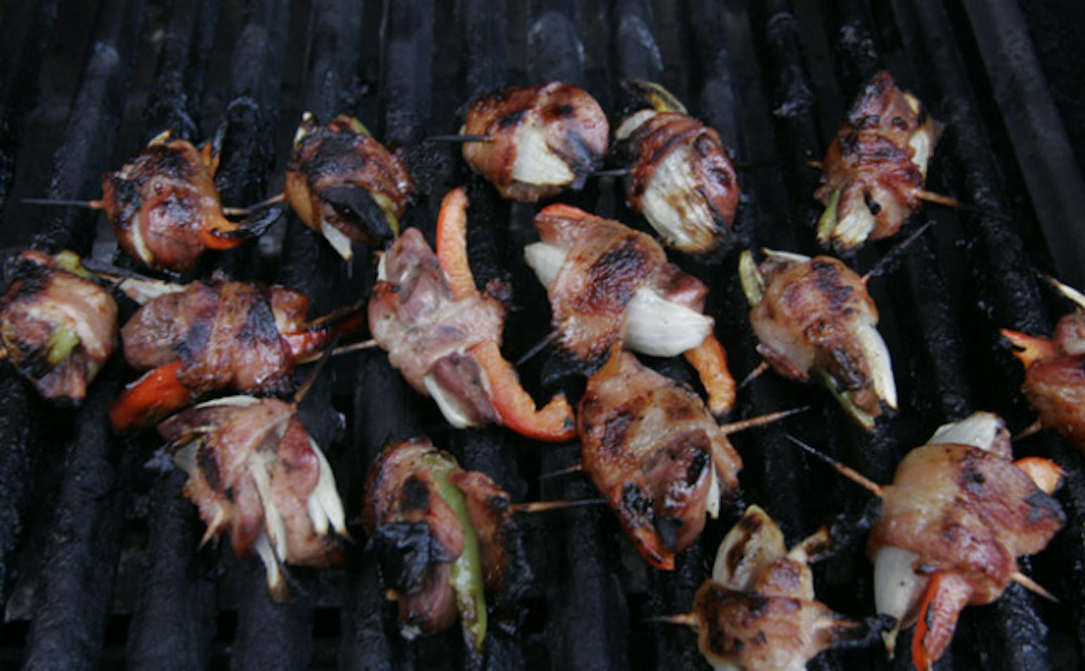 Mourning doves on the grill, wrapped in onion, pepper and bacon.