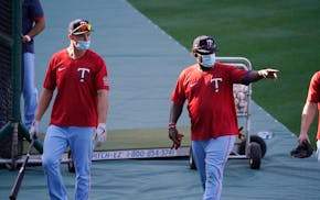 Twins players wear masks during batting practice amid the COVID-19 pandemic, before a game against the Angels on Friday