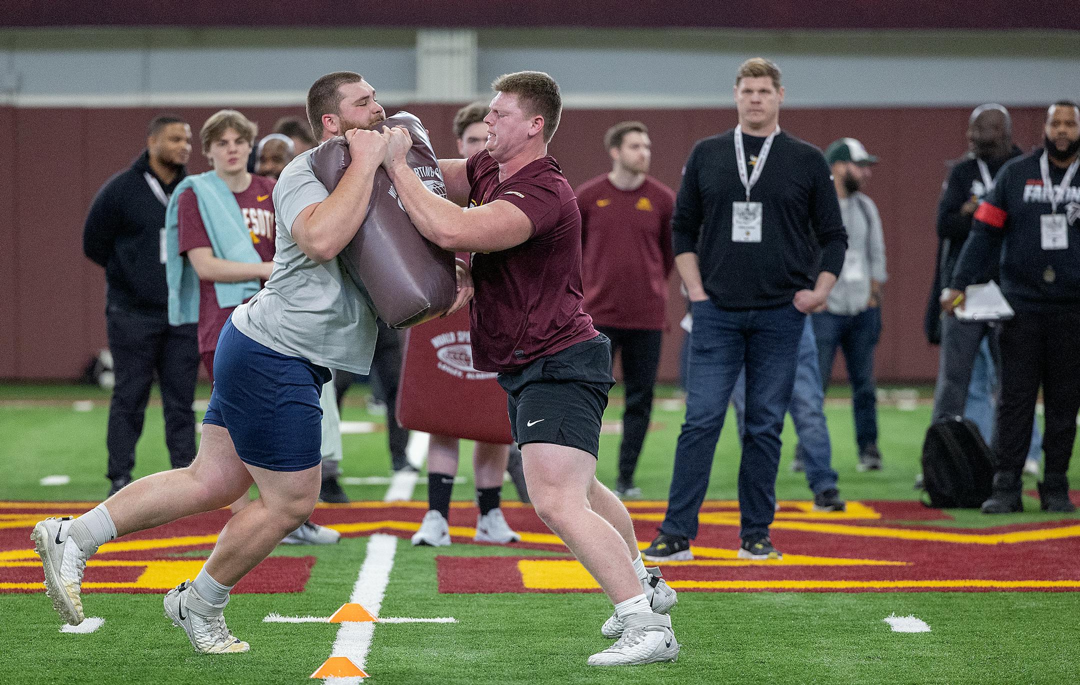 Minnesota center John Michael Schmitz, right, performs for scouts during the Minnesota Pro Day.