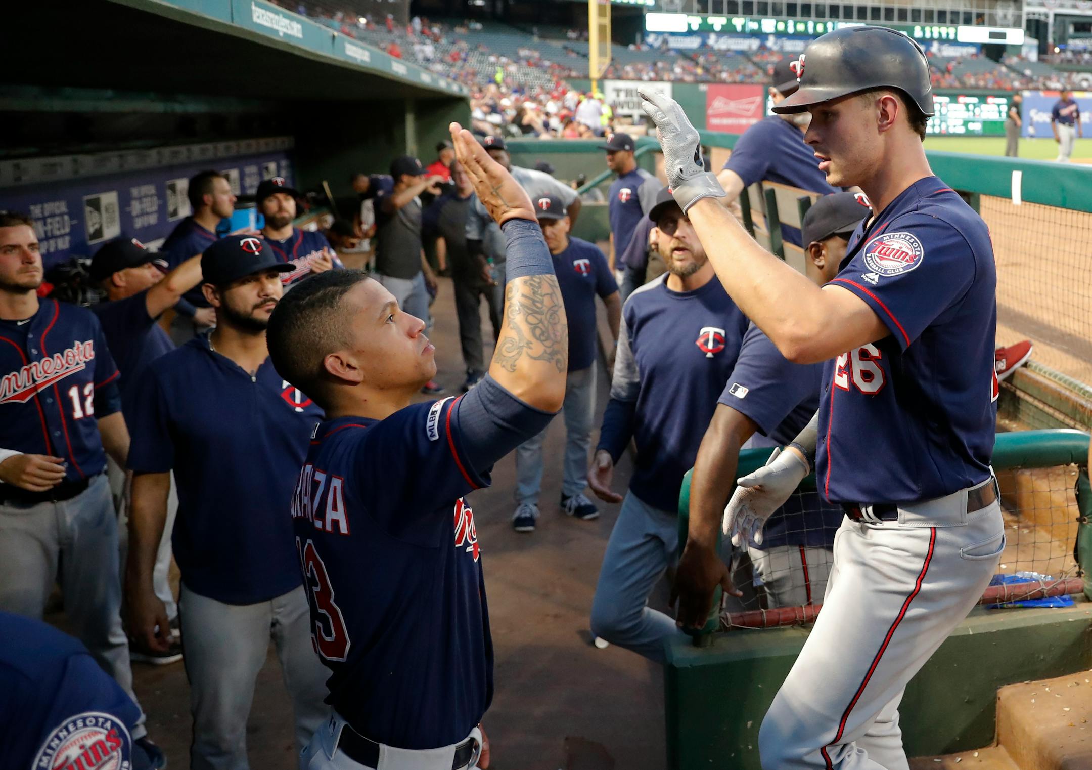 The Twins' Max Kepler, right, left Sunday's game after playing center field in the sun for six innings, with a condition described as "heat illness." The Rangers will play in air-conditioned Globe Life Field next season.