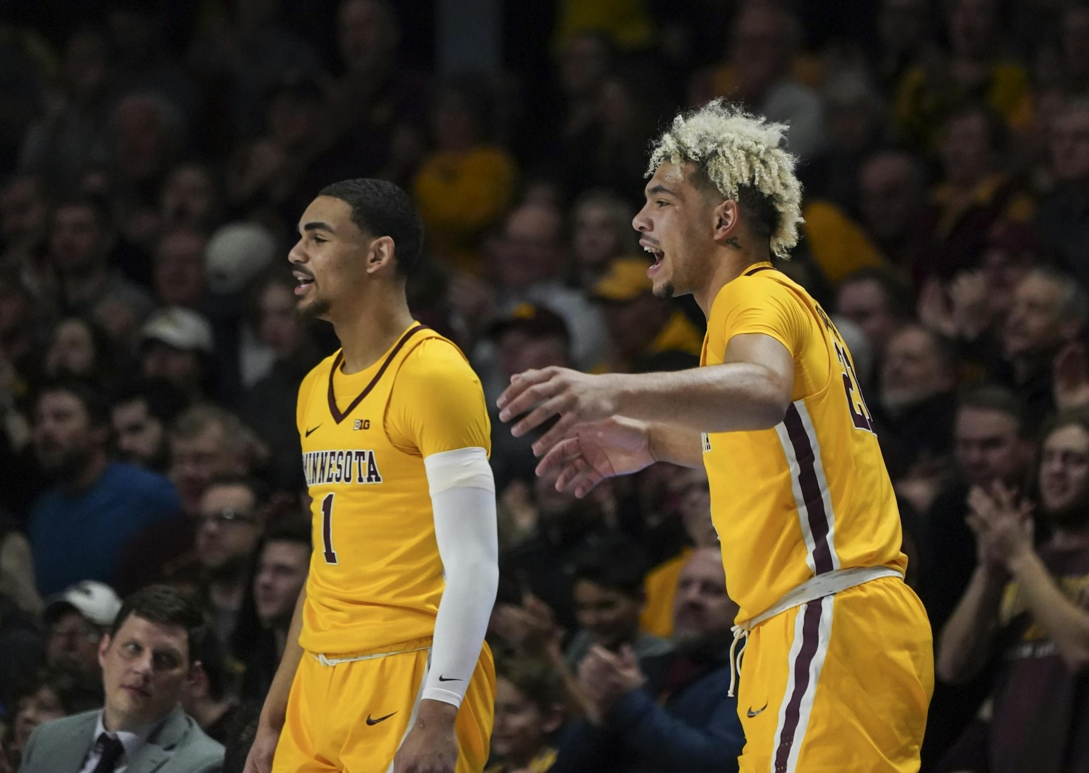 Minnesota Gophers guard Tre' Williams (1) and Minnesota Gophers forward Jarvis Omersa (21) celebrated Minnesota's lead from the bench in the first half.