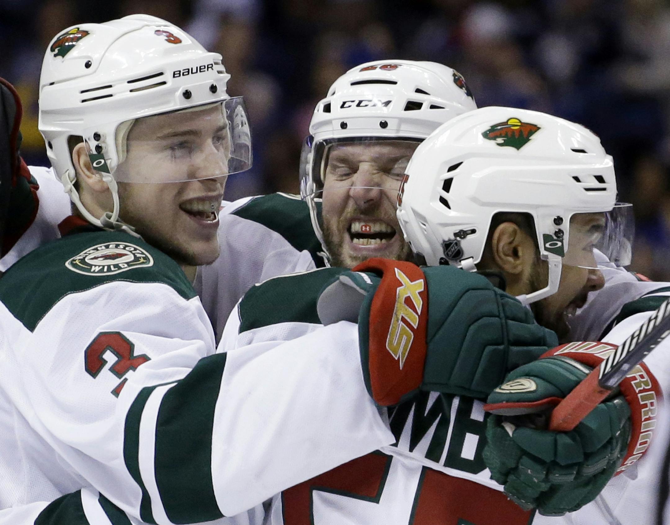 Minnesota Wild's Charlie Coyle, left, is congratulated by teammates Thomas Vanek, of Austria, and Matt Dumba, right, after scoring during the third period in Game 5 of an NHL hockey first-round playoff series against the St. Louis Blues, Friday, April 24, 2015, in St. Louis. The Wild won 4-1. (AP Photo/Jeff Roberson)