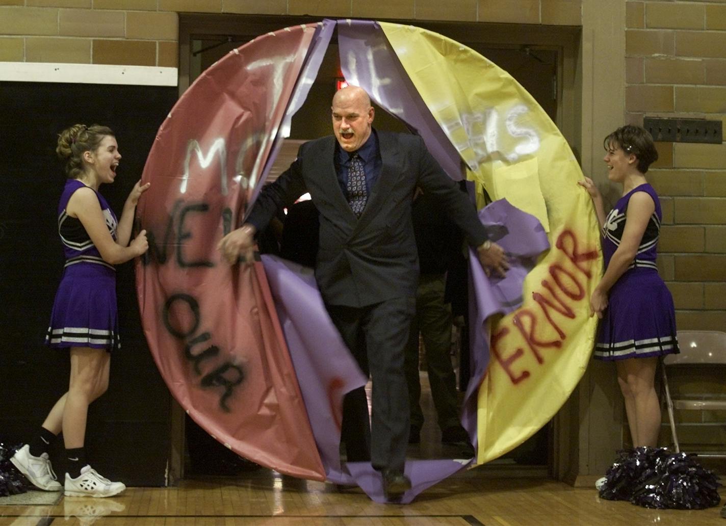 SLAYTON, MN - 1/11/2000 - TUE - Minnesota Governor Jesse Ventura on a two day swing thru thirteen SW Minnesota communities found an enthusiastic constituancy on the streets, in the schools and cafes everywhere he went. At the Murray County Central School, he entered the packed gymnasium thru a large paper hoop reading, "THE MCC REBELS WELCOME OUR GOVERNOR."