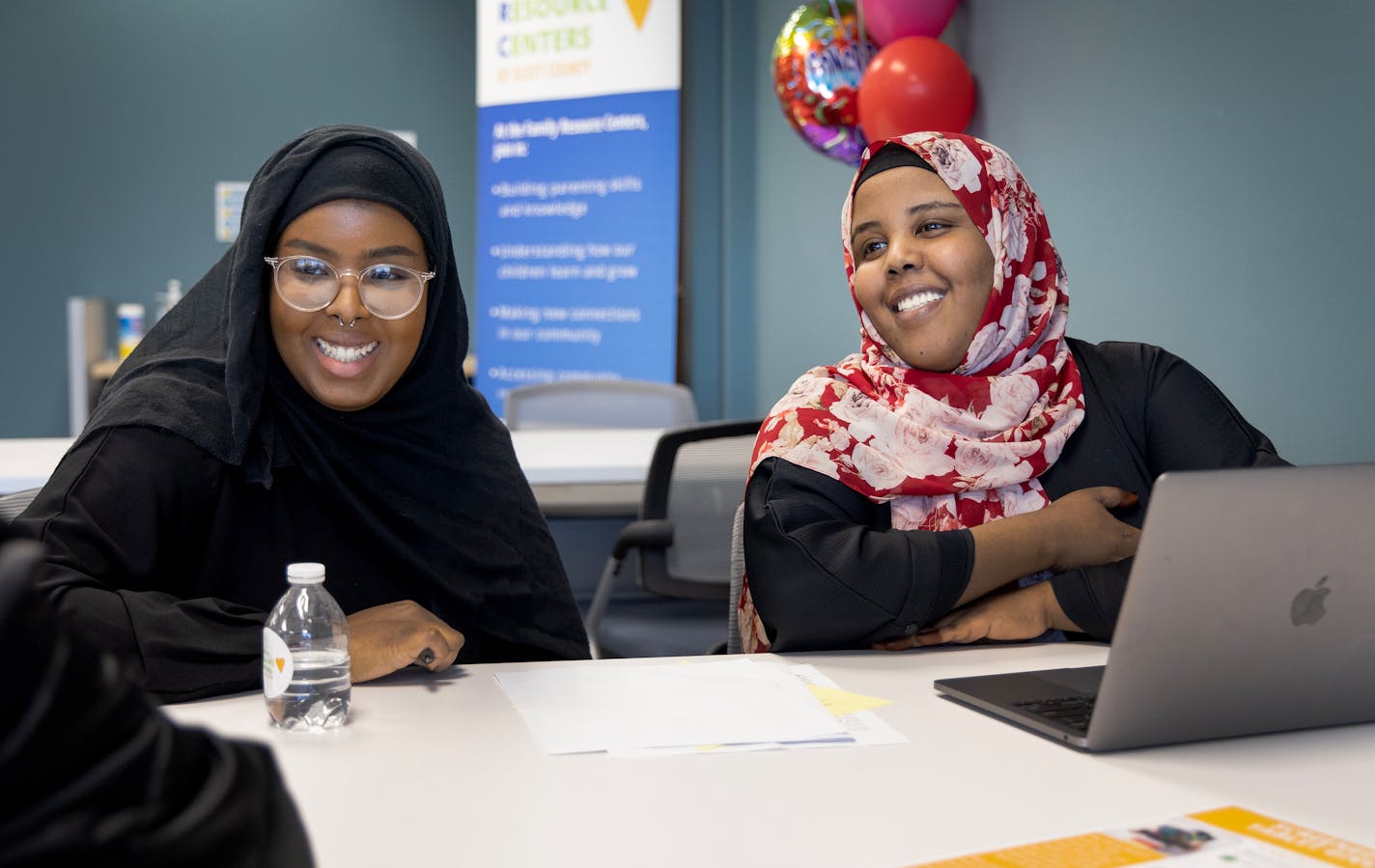 Hafsa Abdi, 22, with the Shakopee Community Resource Center and Zahra Yasin, 28, with Isuroon help a community member with some legal forms Monday, March 20, 2023, at the Family Resource Center in Shakopee, Minn. ] CARLOS GONZALEZ • carlos.gonzalez@startribune.com.