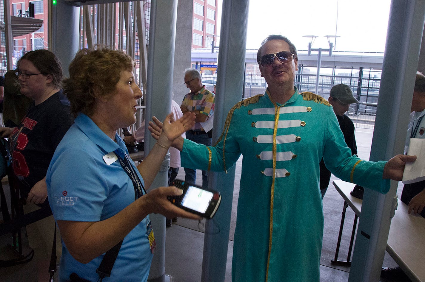 Tom Minehart, from Albert Lea, costumed as Sgt.Pepper, passed through a Target Field security gate. His ticket was being taken by Jill Windmuller from Target Field guest services. ] SHOOT CROWDS BEFORE THE CONCERT GOING INTO TARGET FIELD -- fan features. 249064 McCartney_080314 20035610C (DAVID BREWSTER/STAR TRIBUNE)