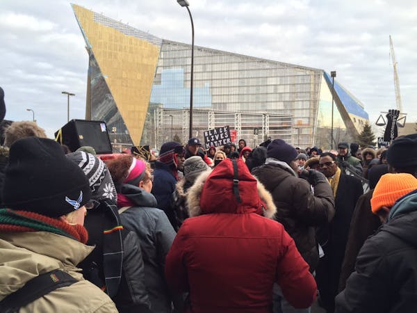 Protesters stopped Saturday outside the Juvenile Detention Center with the Vikings stadium as a backdrop in downtown Minneapolis.