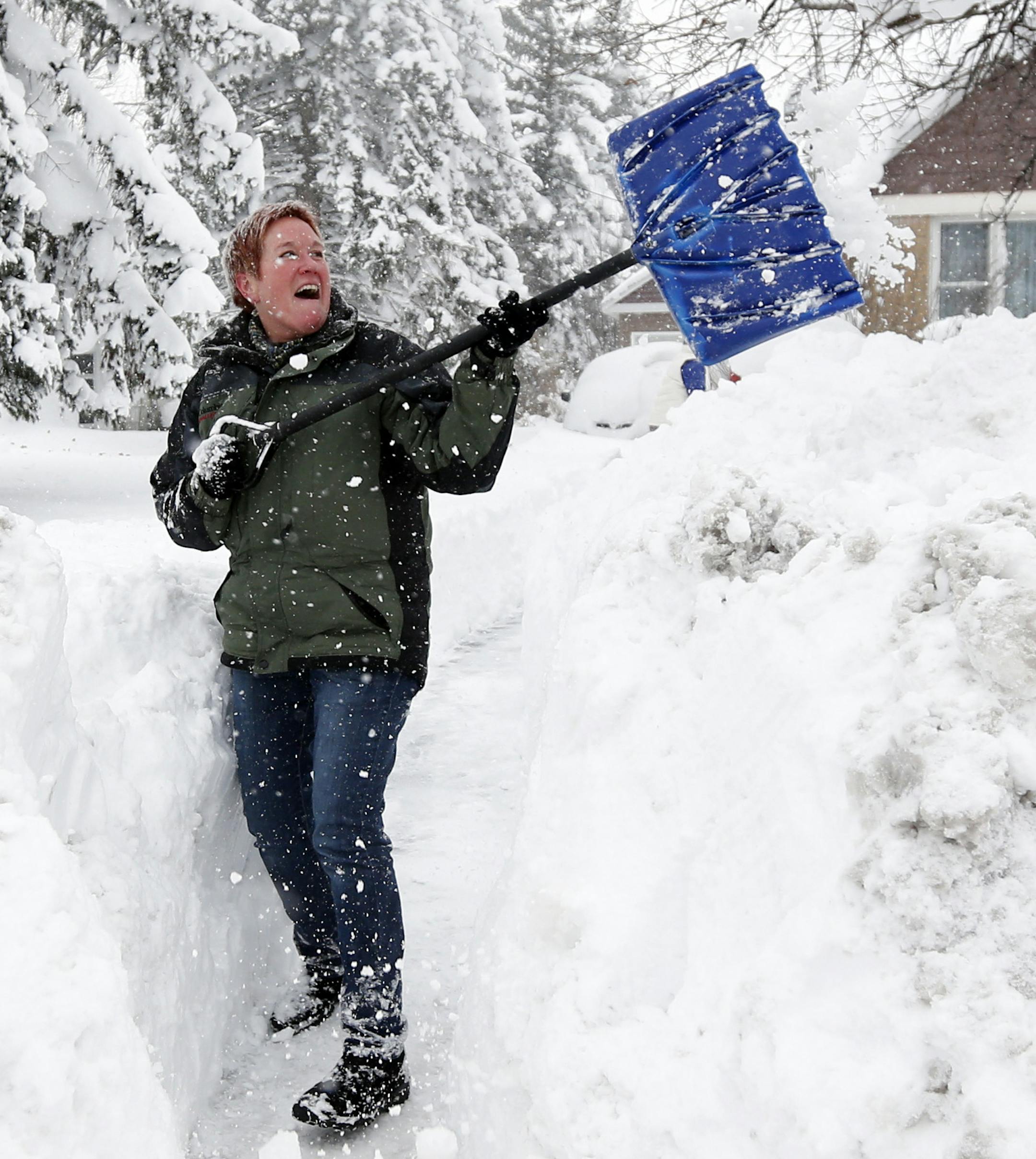 Sue Radka helps shovel out a friends driveway on Wednesday, Nov. 19, 2014, in Lancaster, N.Y. Lake-effect snow pummeled areas around Buffalo for a second straight day, leaving residents stuck in their homes as officials tried to clear massive snow mounds with another storm looming. (AP Photo/Mike Groll)