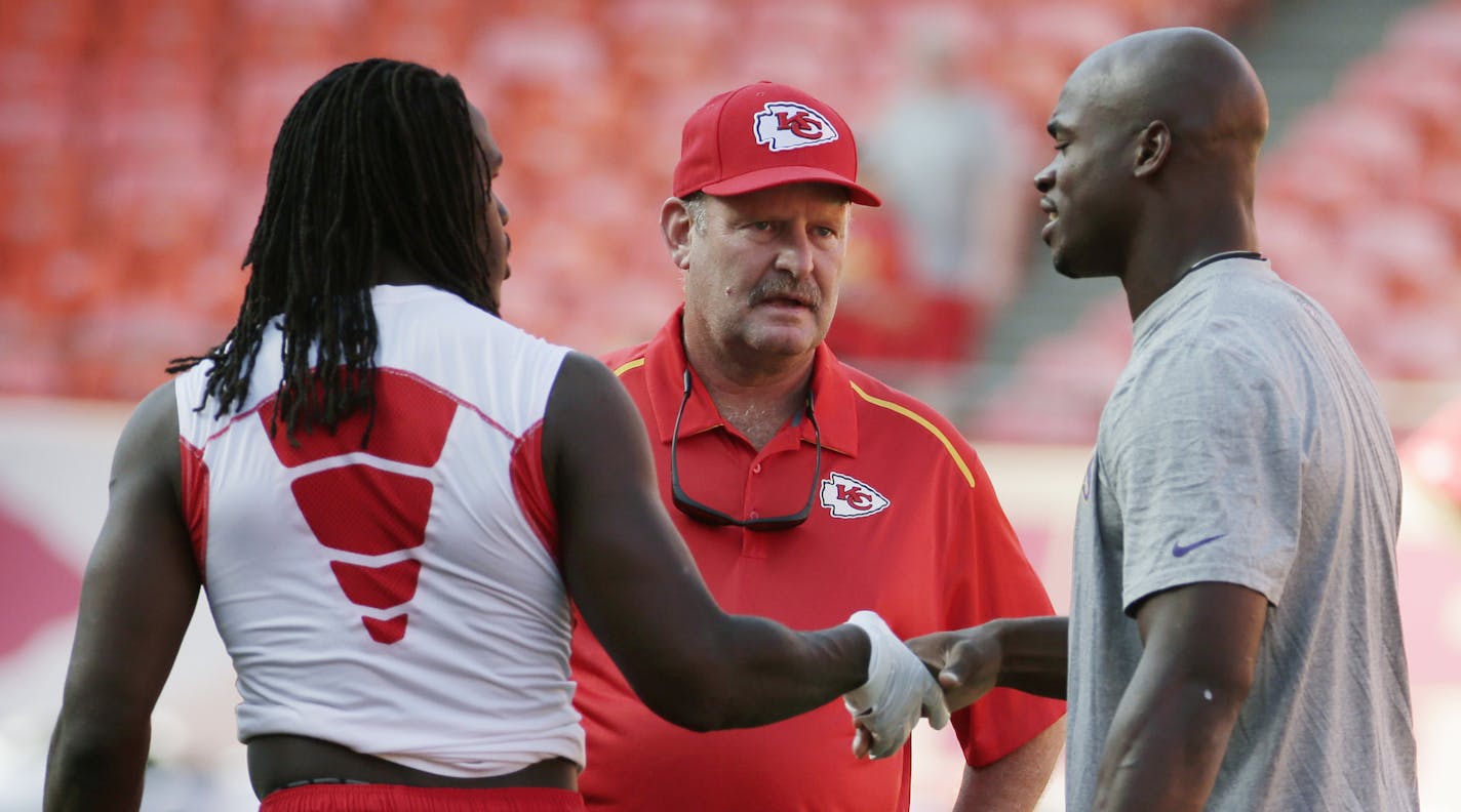 Kansas City Chiefs running back Jamaal Charles, left, shakes hands with Minnesota Vikings running back Adrian Peterson, right, as former Vikings coach and current Chiefs spread game coach Brad Shildress, center, looks on before an NFL preseason football game in Kansas City, Mo., Saturday, Aug. 23, 2014. (AP Photo/Charlie Riedel)